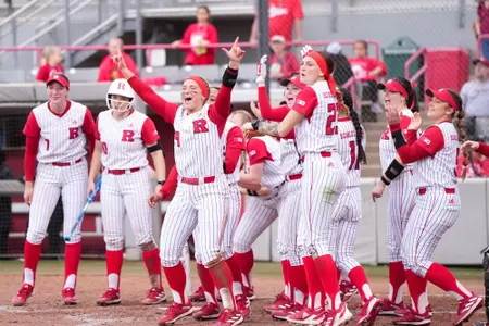 The Rutgers softball dugout cheers after a home run during the Houston Invitational during opening weekend