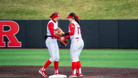 Kyleigh Sand and Maddie Lawson shake hands at second base in the series opener against Nebraska at the RU Softball Complex