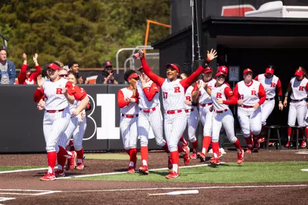 Members of the Rutgers softball team empty the dugout following a victory over Nebraska at the RU Softball Complex