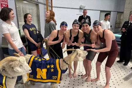 Rutgers' ECAC Championship 200 medley relay team of Natalie Schick, Ellie Schinsky, Molly Urkiel & Brooke Thompson chopping with navy mascot Bill The Goat