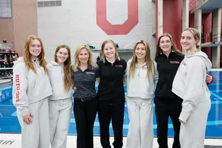 Head coach Natasha Chickina and members of the Rutgers diving team celebrate Bailey Sturgill's podium finish on platform at the 2025 Big Ten Championships