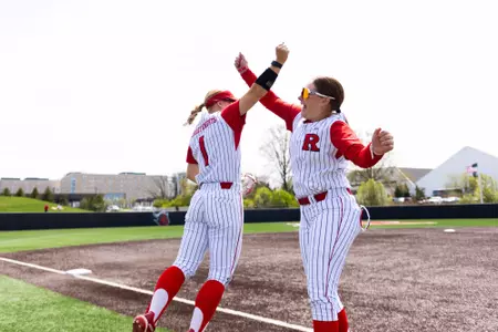 Jillian Anderson and Leah Sims high five before taking on Northwestern at the RU Softball Complex