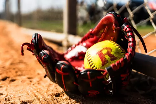 Rutgers Block R softball in glove on dirt - general