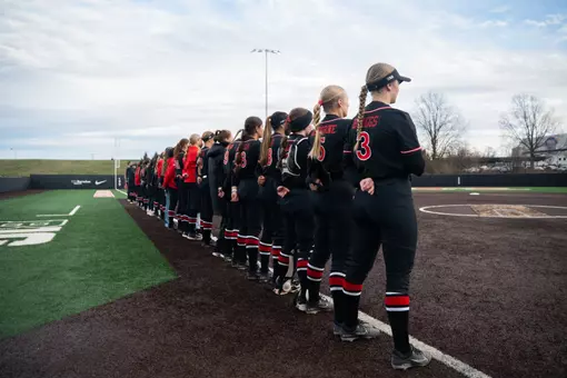 Rutgers softball lines up along third base during the national anthem for the opener of the Penn State series at the RU Softball Complex