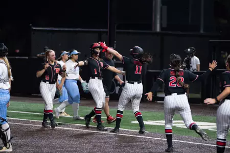 Sam Delhoyo hugs Mia Mitchell following her walk hit in Rutgers softball's 13-12 comeback against LIU at the RU Softball Complex