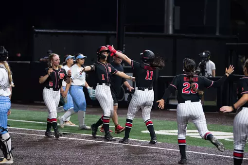 Sam Delhoyo hugs Mia Mitchell following her walk hit in Rutgers softball's 13-12 comeback against LIU at the RU Softball Complex
