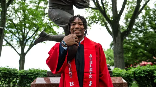 Jordan Thompson graduation photo at statue