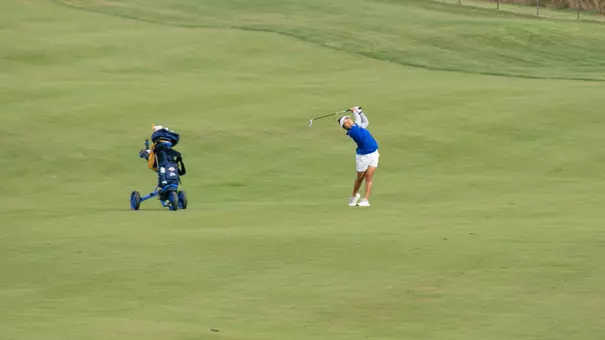 A South Dakota State women's golfer swings a golf club