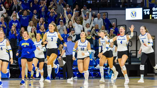 The South Dakota State volleyball team celebrates winning a match against South Dakota