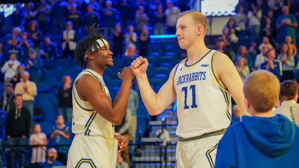 Jaden Jackson and Matthew Mors fist bump before a basketball game