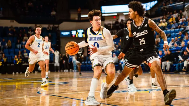 Trey Buchanan dribbles the ball on a basketball court