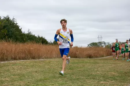 Male runner competes at a cross country meet