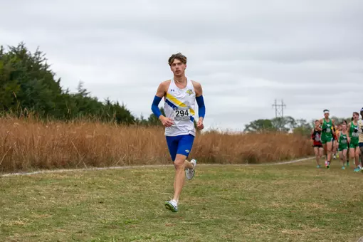 Male runner competes at a cross country meet