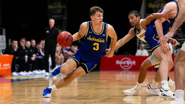 Joe Sayler dribbles a basketball past a defender
