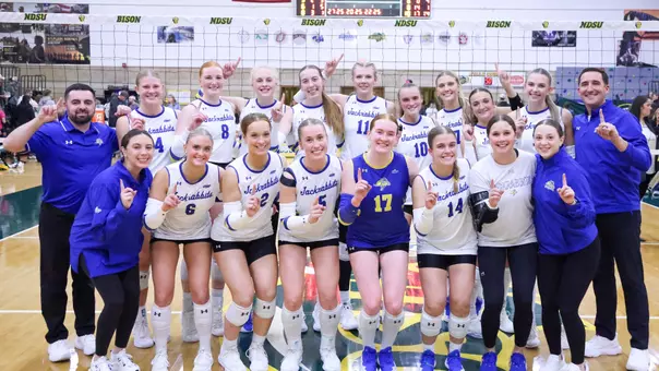 The South Dakota State volleyball team poses for a team photo celebrating clinching a share of the Summit League regular season title