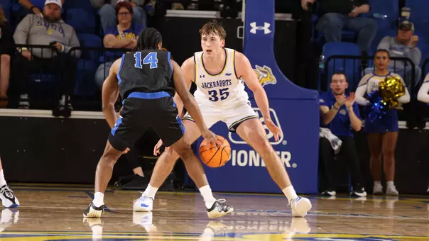 Alec Squires guards a player in a basketball game on October 29, 2025