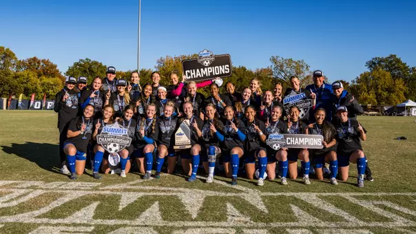 The SDSU Soccer team takes a picture with The Summit League trophy