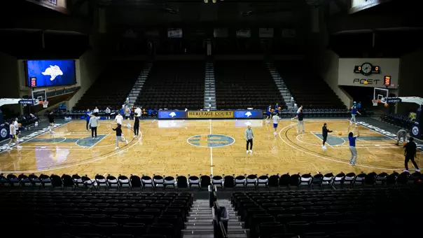 A picture with men's basketball players shooting basketball's on the Sanford Pentagon basketball court