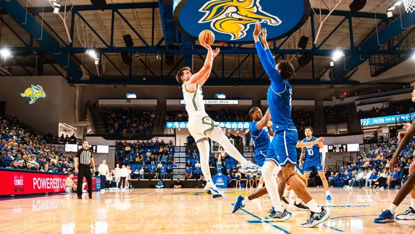 A photo of Luke Haertle shooting a basketball inside First Bank & Trust Arena