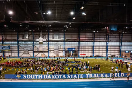 Wide facility shot of the SDSU Sanford Jackrabbit Athletic Complex during a track meet, featuring a banner that says "South Dakota State Track and Field"