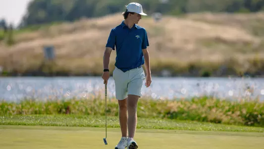 Jacob Wilson walking with a golf club in-hand
