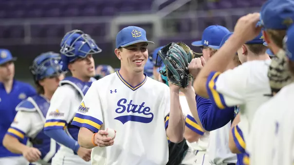 South Dakota State baseball players, led by third baseman Nolan Grawe, tap gloves and bump fists during starting lineup introductions prior to a March 6, 2026, game against Northwestern.