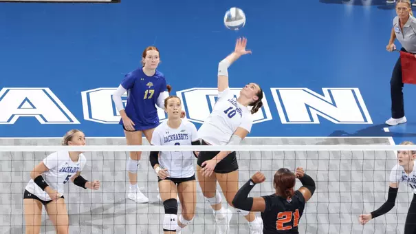 High-angle image of a volleyball player attacking a ball at the net during competition