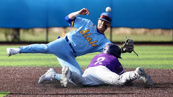 South Dakota State infielder Nic Werk (in blue uniform) attempts to knock down the ball on an attempted steal by St. Thomas' Tanner Recchio in baseball action May 9, 2026, at Erv Huether Field in Brookings, S.D.