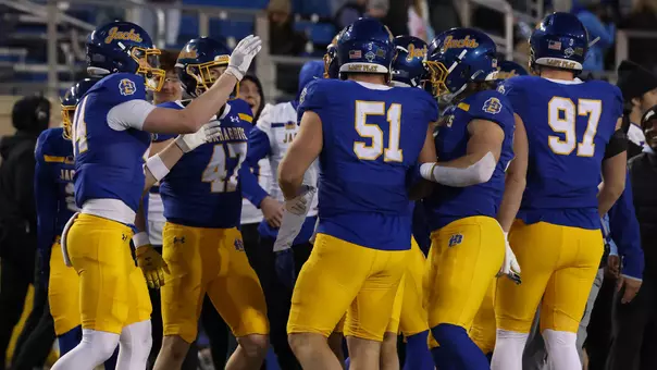 South Dakota State football players congratulate each other after making a defensive stop in action during the 2025 season