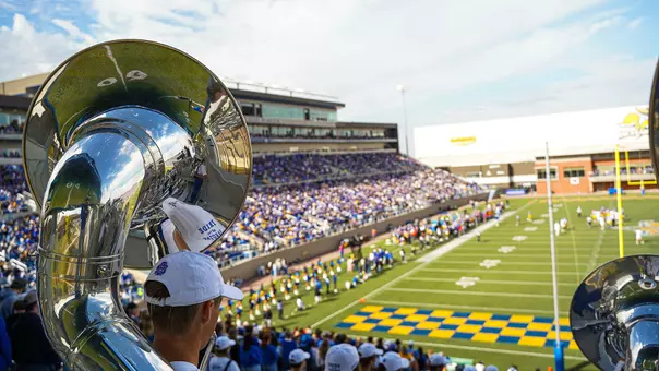 A photo taken inside Dana J. Dykhouse Stadium from the Pride of the Dakotas marching band section in the south end zone and overlooking the playing field.
