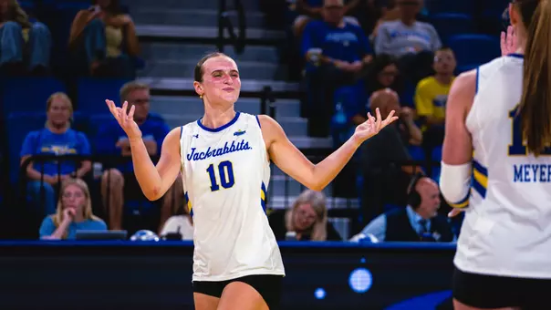 Sylvie Zgonc celebrates after a point by shrugging in a white jersey.