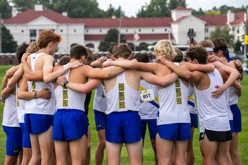 SDSU men's cross country huddles before competing in the 2025 Roy Griak Invitational.