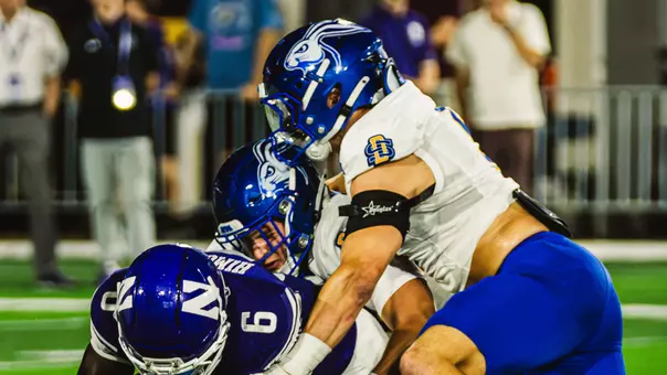 Teaser photo of the South Dakota State defense making a tackle of a Northwestern ball carrier in action Sept. 5, 2026, in Evanston, Illinois.