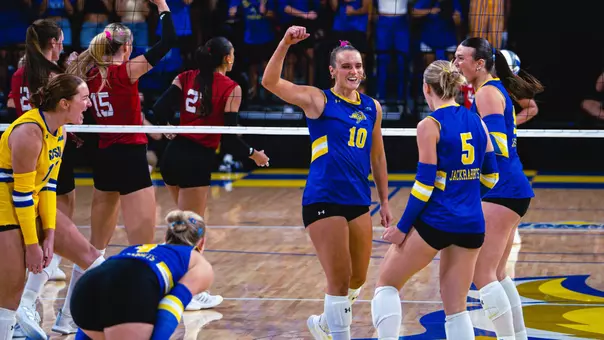 Sylvie Zgonc in a blue jersey celebrates after a point by raising her fist.
