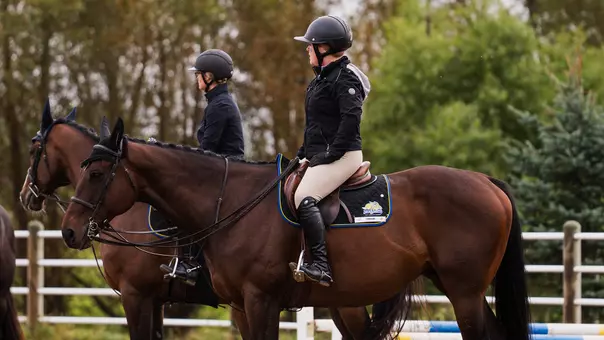 South Dakota State equestrian riders sit on horses awaiting instructions from the coaching staff prior to competition.