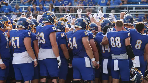 South Dakota State football players huddle before leaving the field during pregame warmups at Dana J. Dykhouse Stadium.