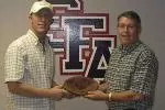 Robert Hill (R) accepts the football from Army SPC Paul Chrismer