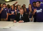 Surrounded by members of the football team, band and spirit squad, Dr. Pattillo signs proclamation making every Friday "Spirit Day" on campus.