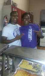Antionette Carter and Daylyn Harris prepare to serve dinner at GODTEL Ministries Monday evening.