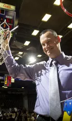 Head coach Brandon Schneider cuts down the nets following SFA's victory over UCA to clinch a share of the SLC title