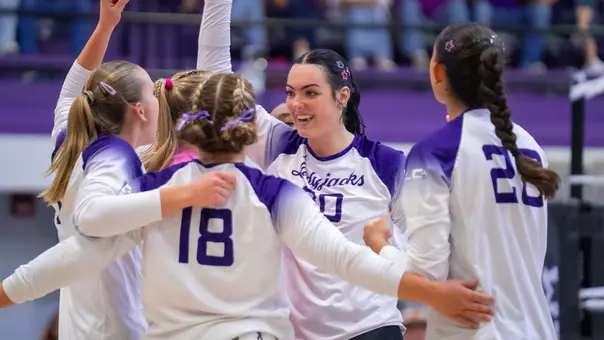 Molly Cravens in huddle celebrating a block vs UTA (9.12.26)