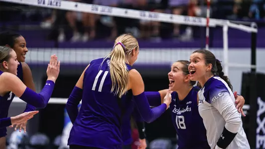 volleyball team celebrating a point vs Loyola Chicago