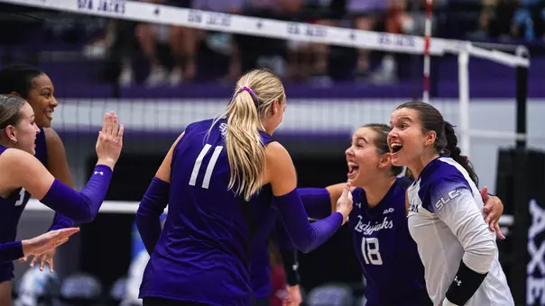 volleyball team celebrating a point vs Loyola Chicago