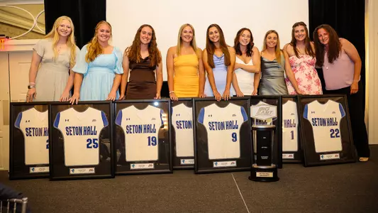 The seniors of the softball team pose with their framed jerseys at the 2023 Senior Awards Banquet