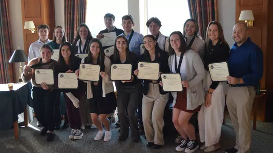 Newest inductees to Chi Alpha Sigma from the swim team pose for a photo on March 30