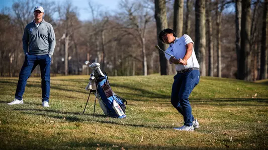 Wenliang Xie takes a shot during a practice round early in 2023 as coach JT Harper watches.