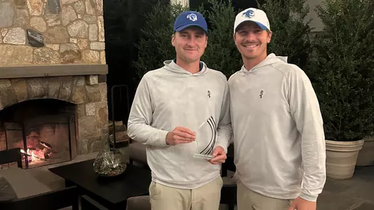 George Fricker poses with head coach JT Harper after winning the GlenArbor Invite on Oct. 20.
