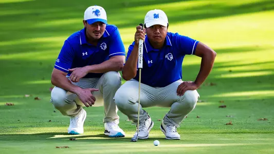 Wenliang Xie and coach JT Harper line up a putt during a practice round in the fall of 2023