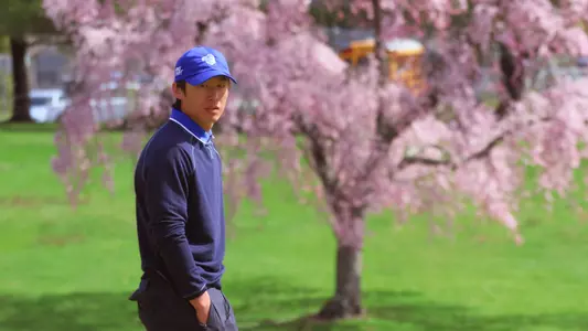 Wanxi Sun poses in front of a cherry blossom tree at Springdale Golf Club