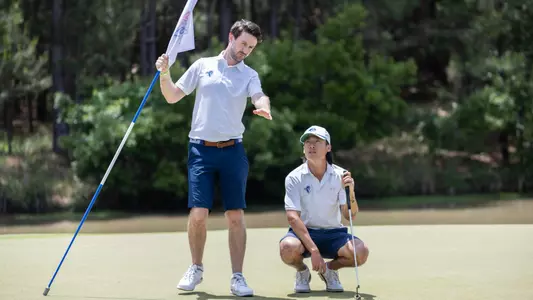 Gary Dunne shows Wanxi Sun the line of a putt